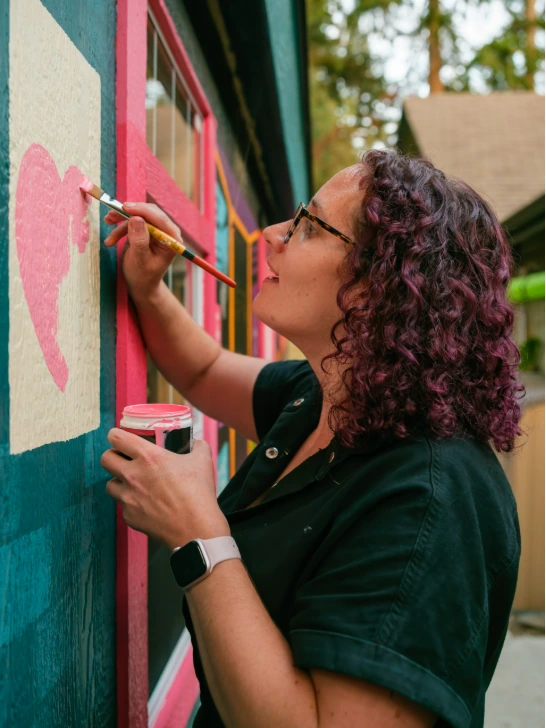 Kami painting a colorful custom mural